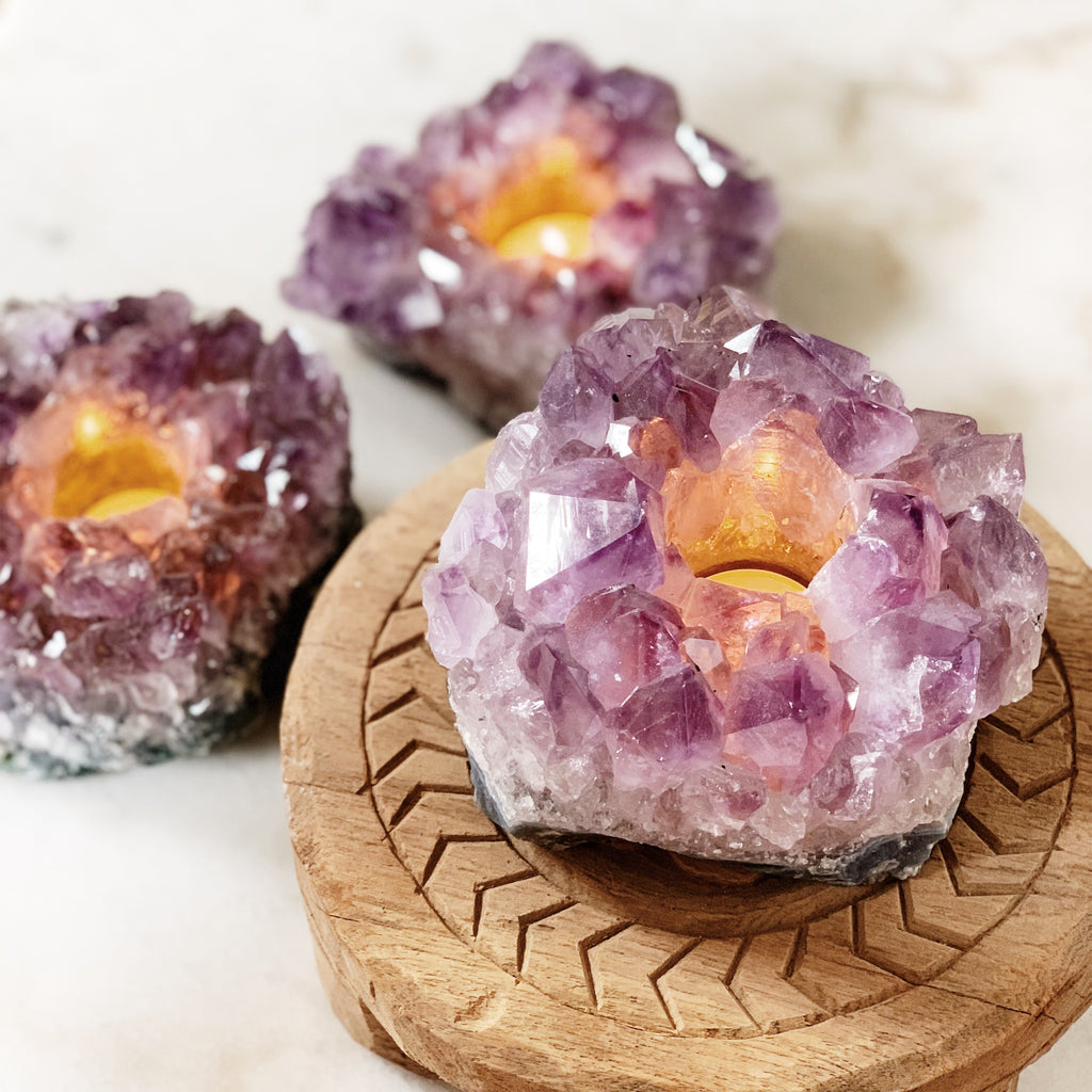 Three Amethyst candle holders with lit tea lights